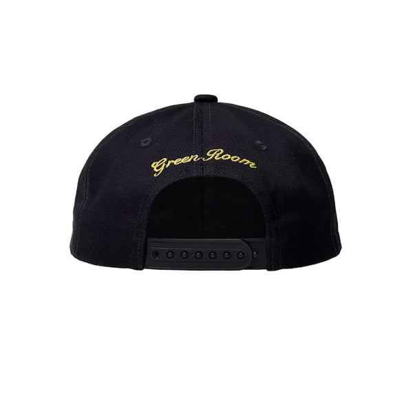  Schwarzer Snapback-Verschluss, darüber in geschwungener gelber Schrift gestickter Text „Green Room“.